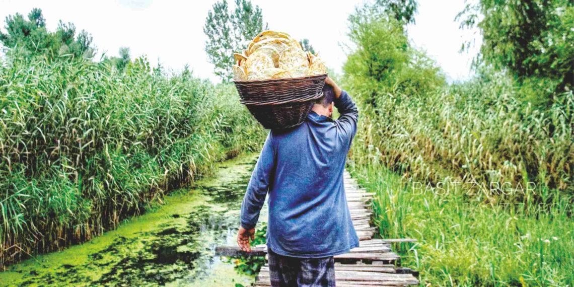 جھیل ڈل کے اندرونی علاقہ میں شہری کندھوں پر تازہ روٹیوں کا ڈھیر لیتے ہوئے۔۔۔۔ساحل میر